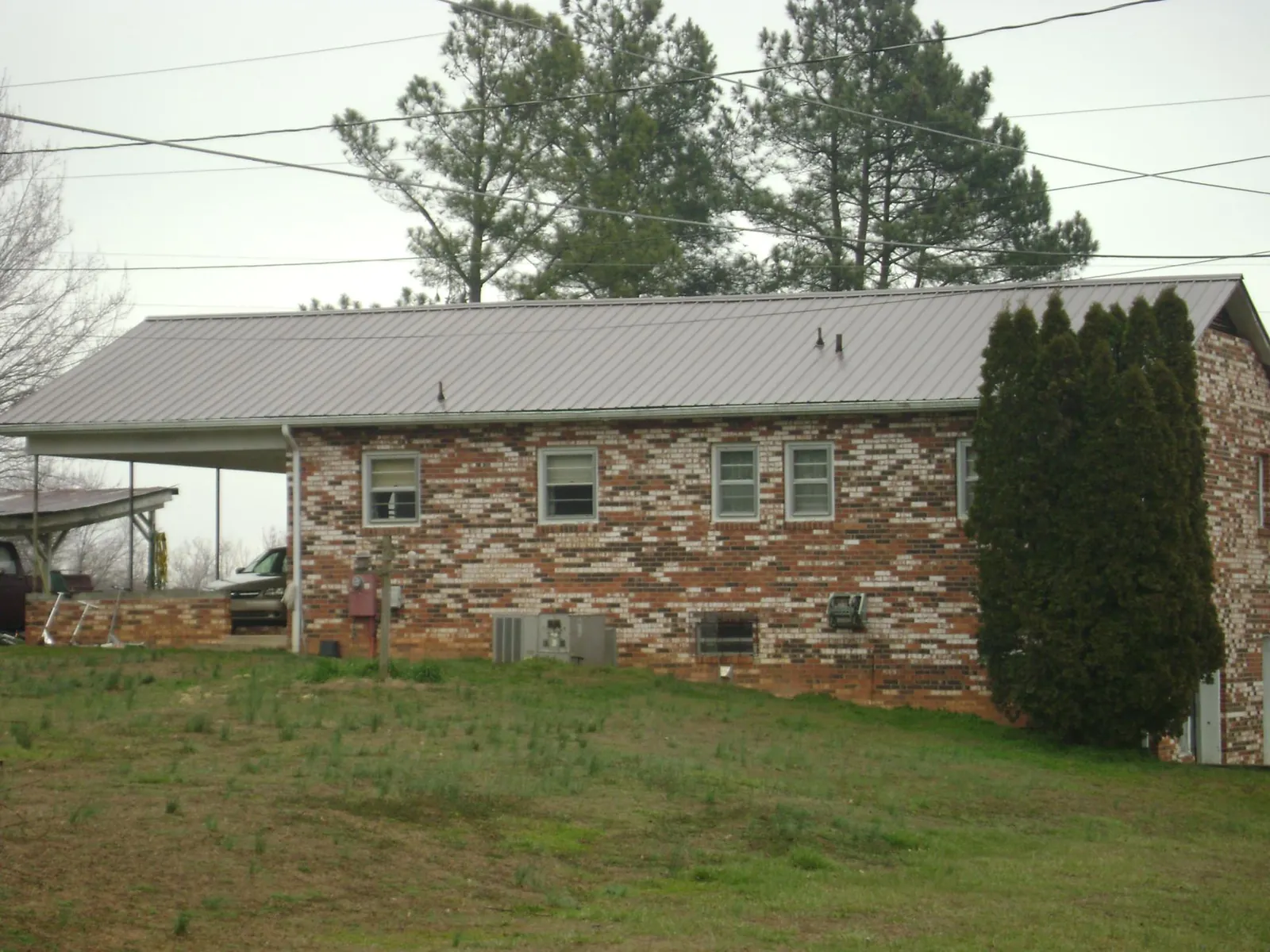 Gray metal roof on a brick split level home with a carport in Meridian